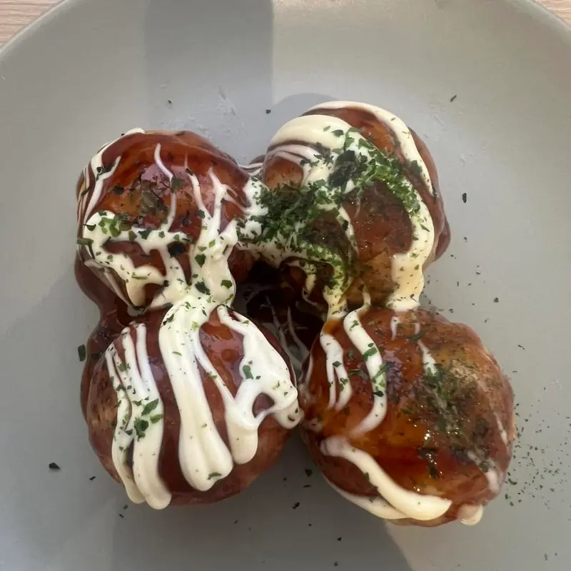 Four takoyaki seen from above with sauce, mayo and nori